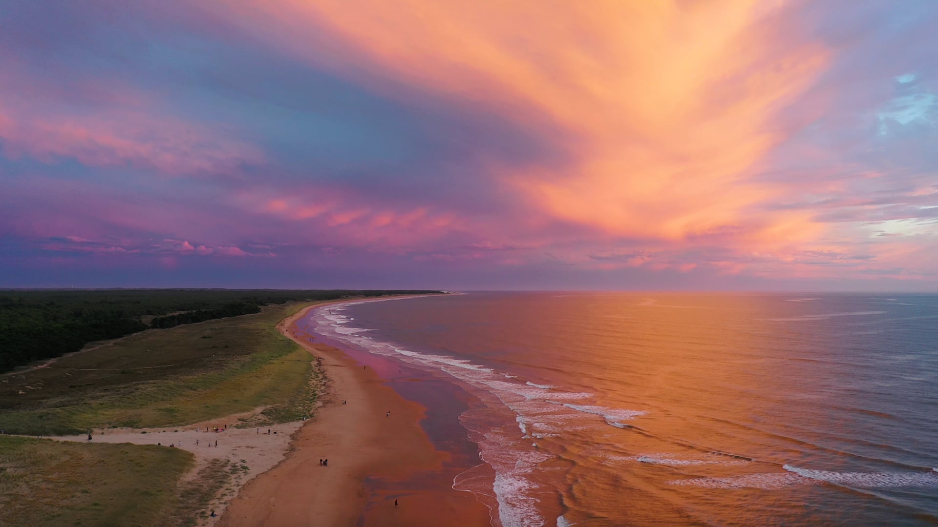 Orange and lavender sunset above a sweeping coastline, from Nathan’s aerial film collection